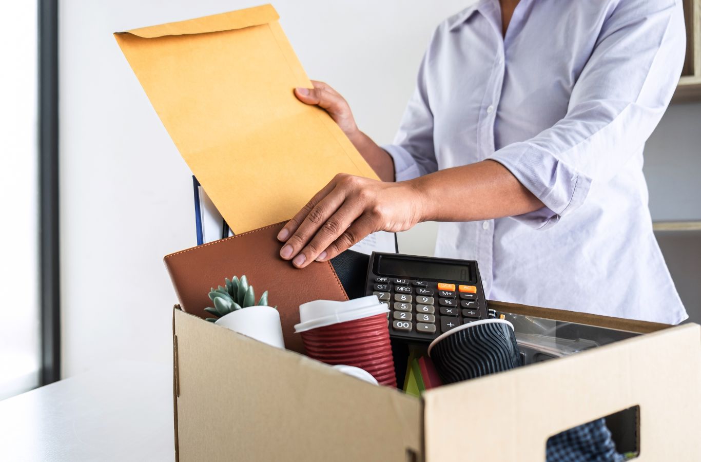 femme emballant une boîte à son bureau