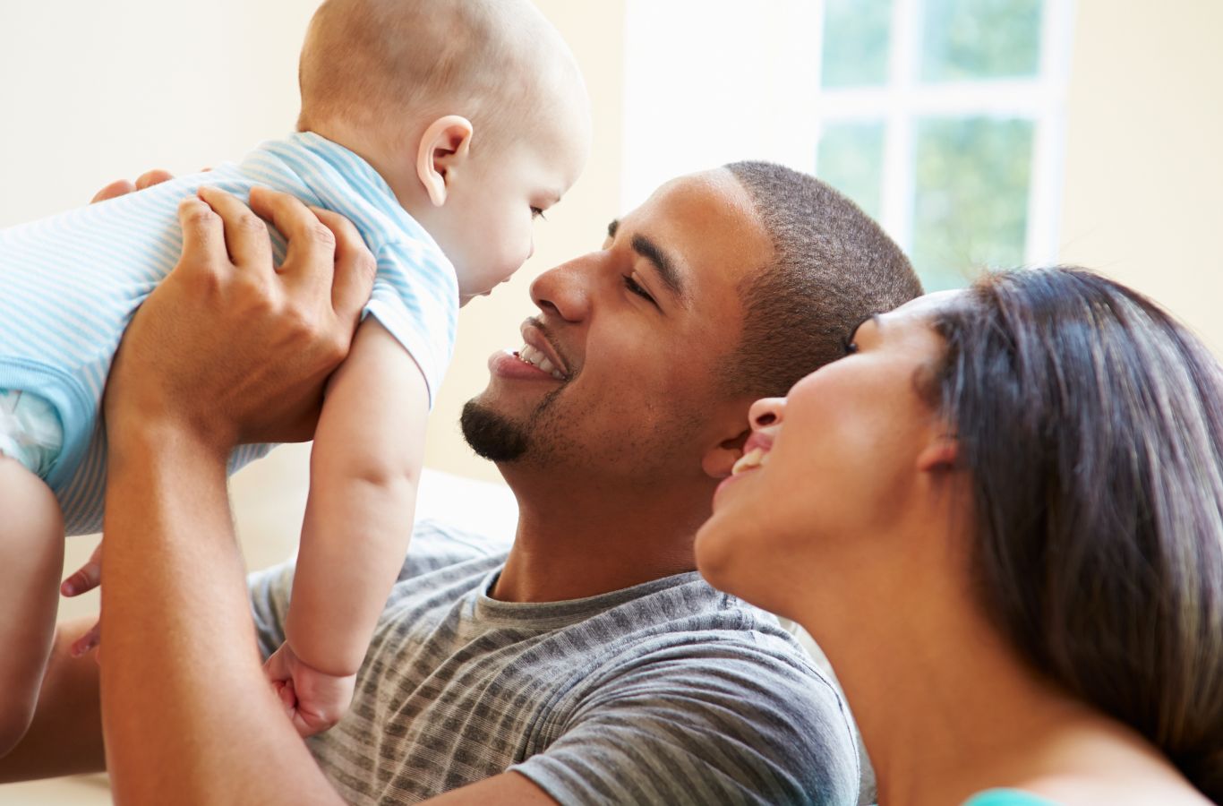 Young couple holding their baby smiling